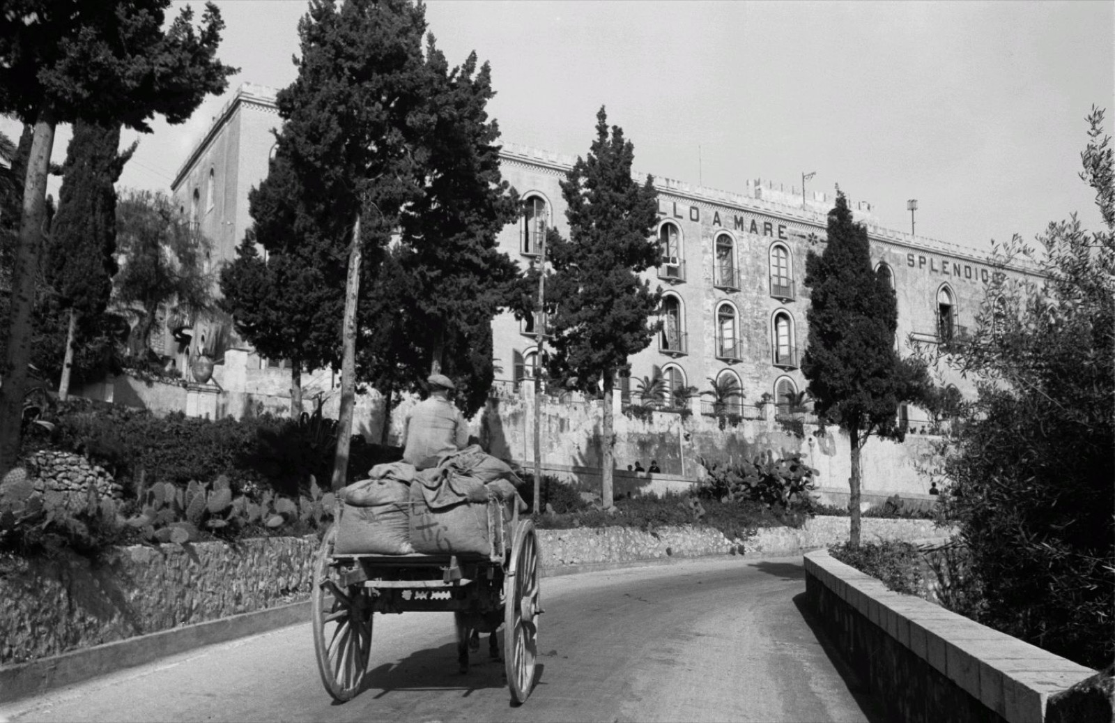 Travel photos Italy. Sicily. Taormina. Street picture with carts. View of the hotel “Castello a mare”, Castello a Mare