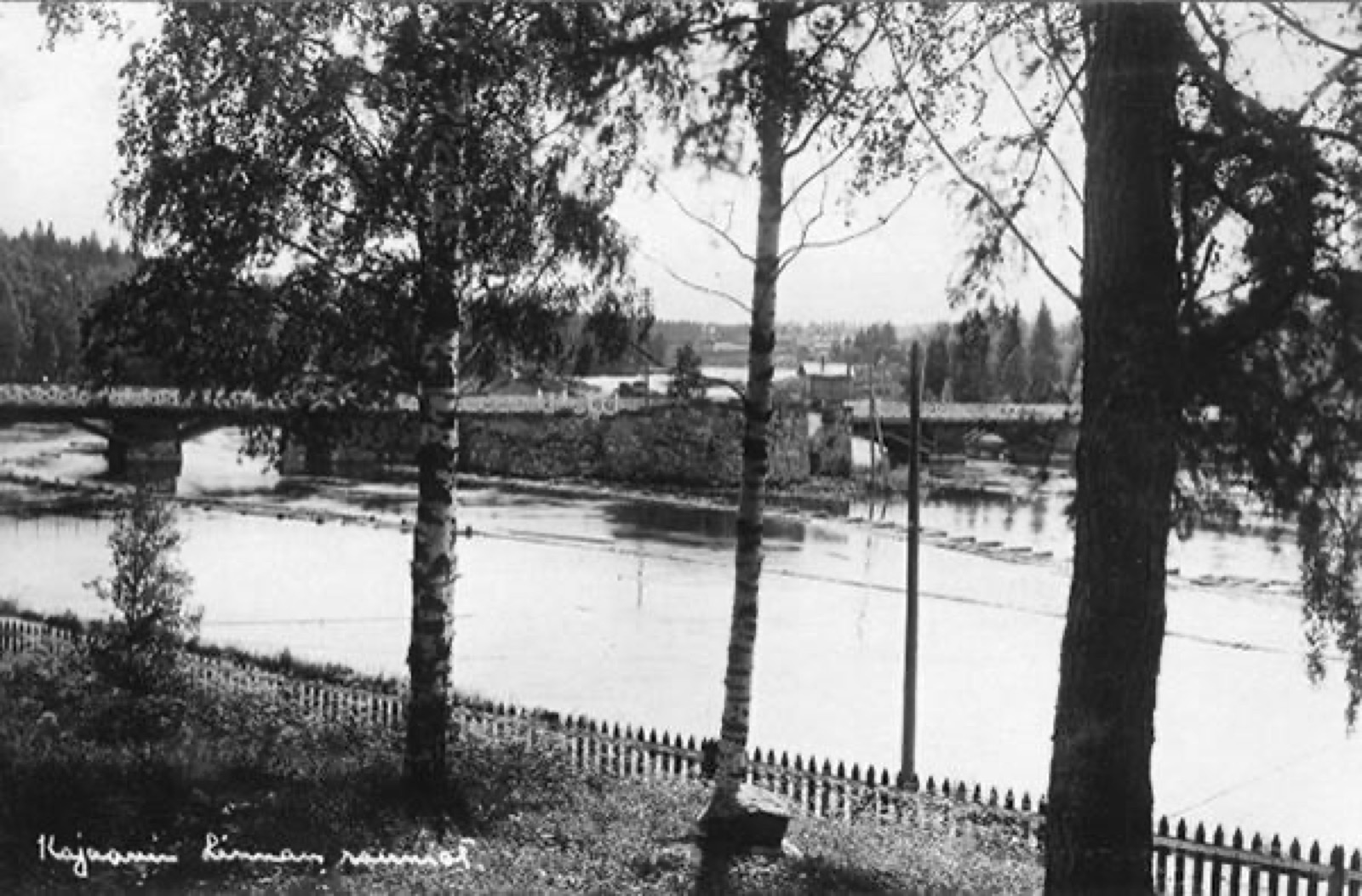 Kajaaninjoen yli vievä silta ja linnan rauniot. Kuvan oikeassa alakulmassa teksti:Kajaanin linnan rauniot, Kajaani Castle
